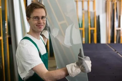 Intervenant portant un panneau de verre avec des gants
